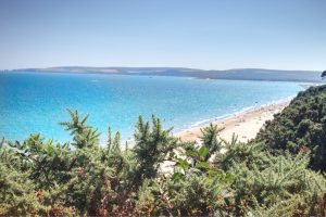 Canford Cliffs Beach - Mediterranean like Dorset beach elevated view with turquoise sea glistening against a cloudless sky