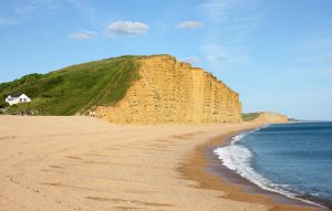 West Bay - sandy beach backed by high grass topped cliffs