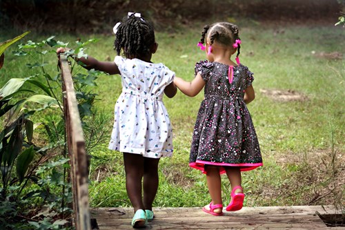 2 girls walking down a bridge