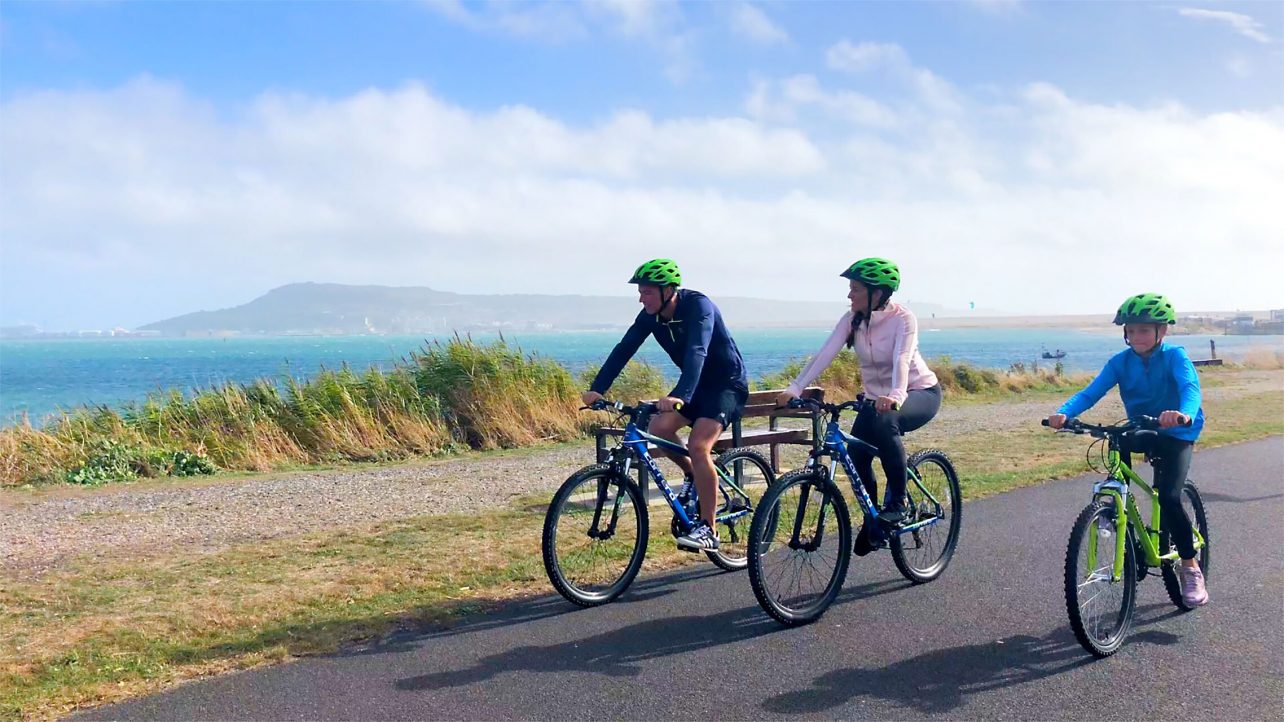 A couple cycling along a beautiful coastal path in the south west of England